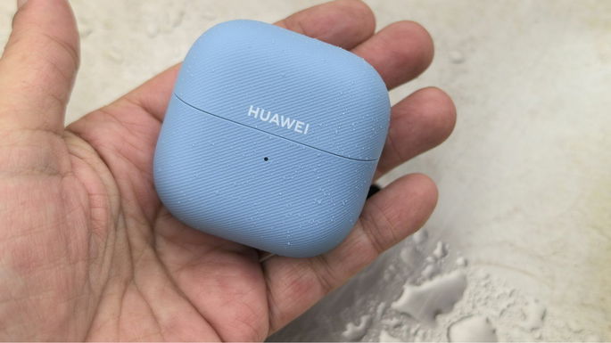 Huawei FreeClip 2 abertos na m&atilde;o com fundo &aacute;gua